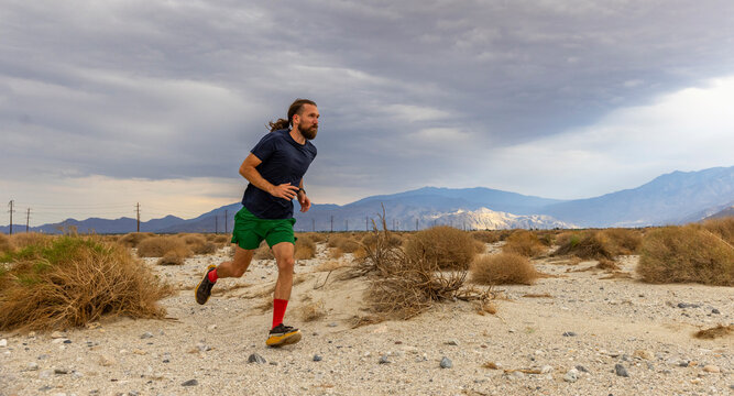 Athlete trail running desert Wind turbine landscape