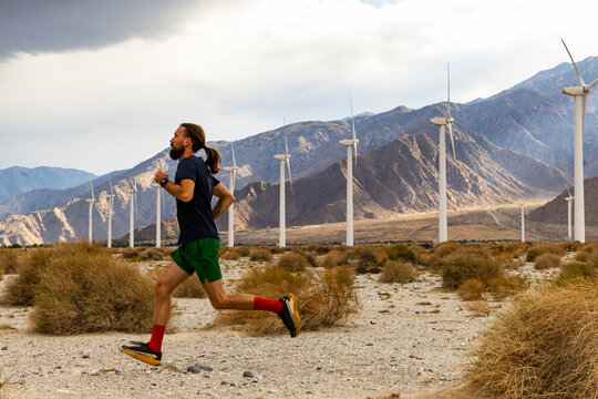 Athlete running desert Wind turbine farm 