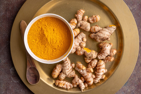 Turmeric Root and Powder on a Gold Plate for Culinary Use