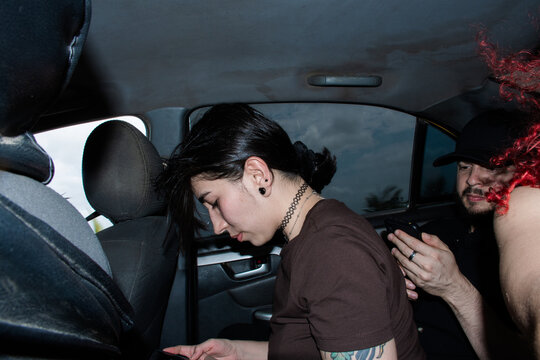 People Sitting in a Car Interacting With Their Phones