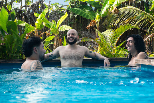 Friends Enjoy Time in Pool Surrounded by Tropical Plants and Trees