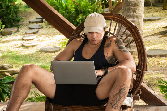 Man Working on Laptop in Outdoor Setting During Daytime