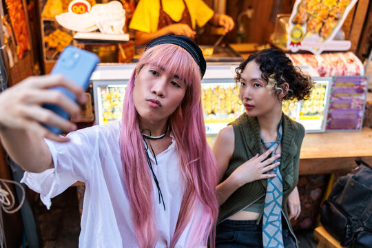Friends take a selfie at a street food vendor.
