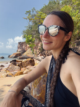 selfie of a female in reflective sunglasses at the beach