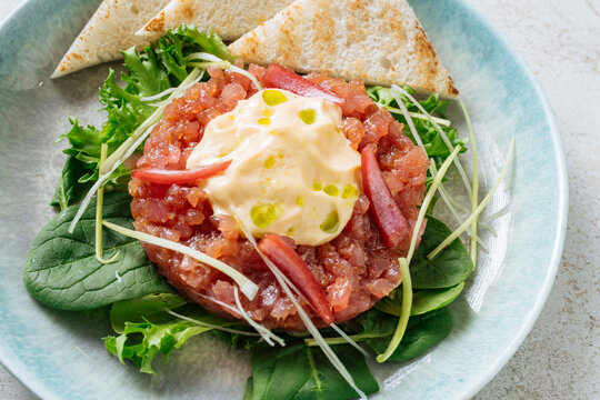 Close-up of tuna tartare with greens and toast 