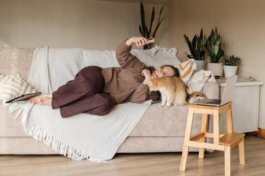 A woman making selfie with her cat at home by smart phone.
