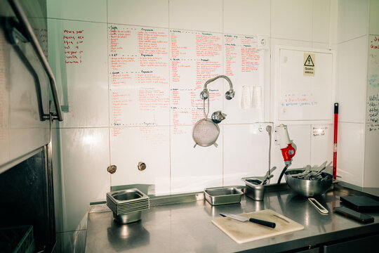 Kitchen Workspace With Notes on the Wall and Utensils on the Counter