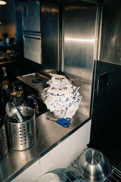 Notes and Utensils on Counter in Busy Kitchen During Service Hour
