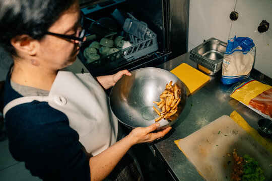 Woman Prepares Food in a Kitchen While Working With Ingredients