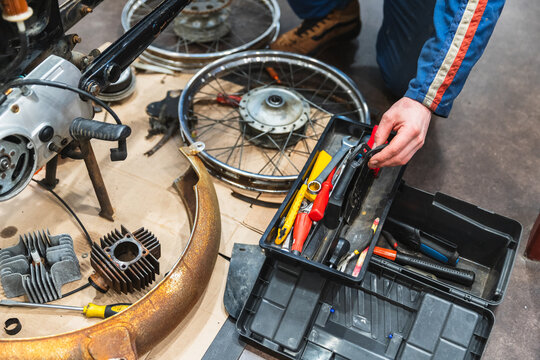 Mechanic Working on Red Vintage Motorbike Restoration