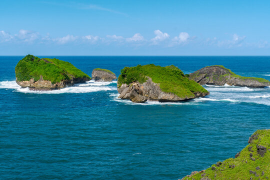 Rocky islands seascape at Pantai Kasap, Pacitan, East Java, Indonesia, tropical paradise with dramatic coastal cliffs and summer ocean view.