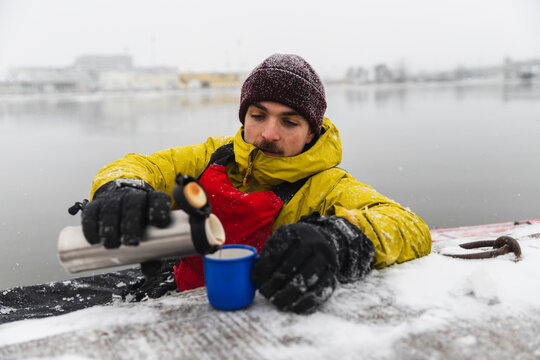 Pouring Hot Coffee from Thermos During Winter Kayak Break