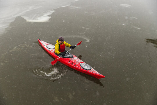 Top View of Red Kayak Navigating Icy Dark Ocean Waters