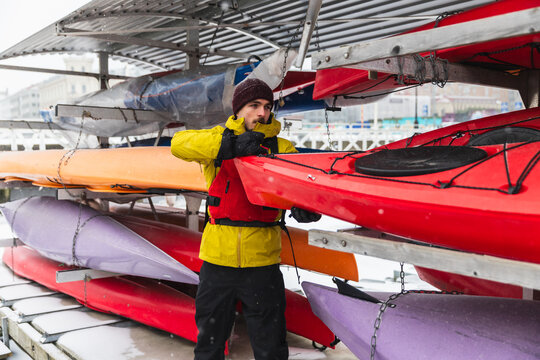 Adventurer Preparing Kayak on Frozen Ocean Shore in Winter