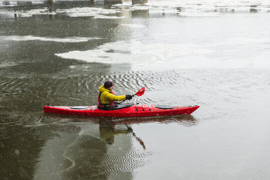 Profile View of Kayaker Paddling in Misty Scandinavian Harbor