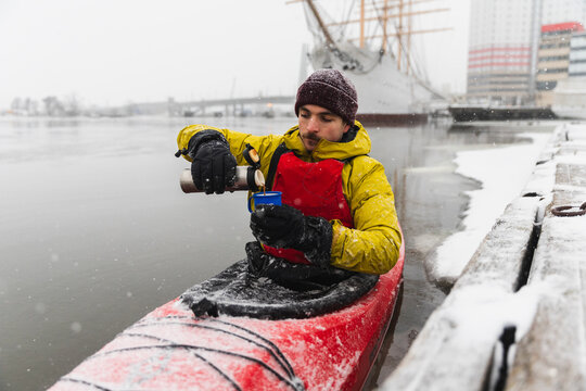 Pouring Hot Coffee from Thermos During Winter Kayak Break