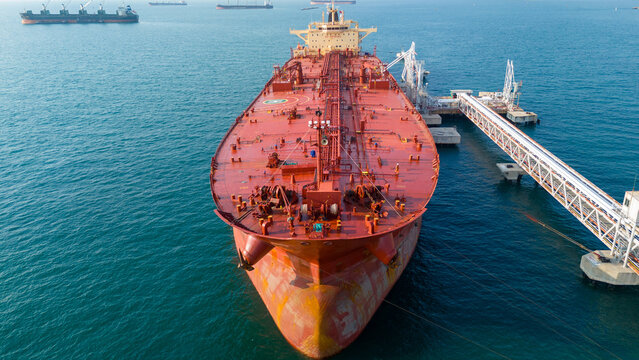 Massive oil tanker ship at maritime loading terminal for global energy logistics and petroleum freight transport. International cargo supply chain, crude oil export