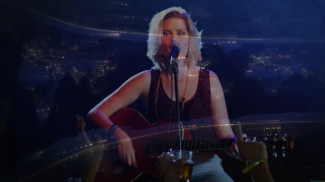 Light blur starting then easing, singer playing with guitar strumming and singing to engage crowd