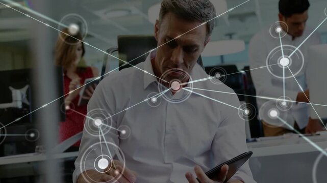 Seated man editing tablet, nodes sliding in forming web covering him and desks for business