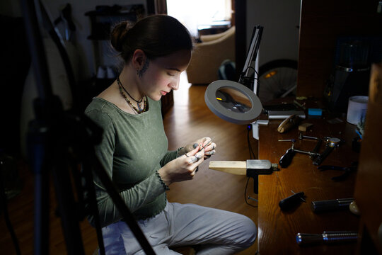 a woman makes jewelry
