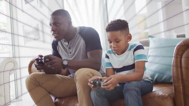 Father and son on sofa, pressing pads, radial stars radiating around them during gaming for bonding