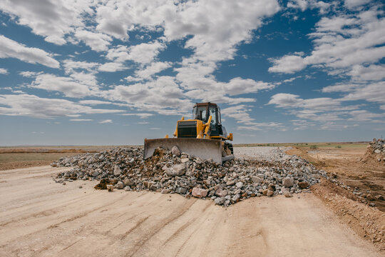 Bulldozer Leveling Rocks on Construction Site