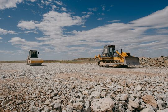 Bulldozer and Road Roller Working on Gravel Road Construction