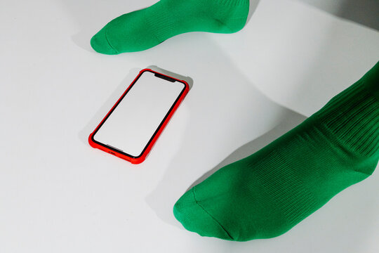 a man stands over a blank smartphone on a table