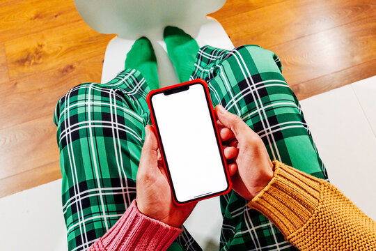 a blank phone screen centered above crossed legs