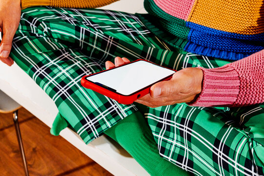a smartphone with a blank screen resting on his palm