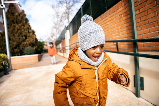 Happy black child running outdoor in winter