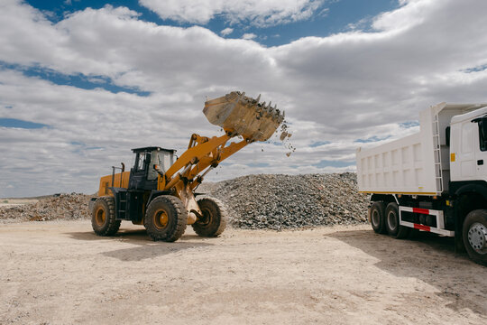 Loader Dumping Rocks Into Truck at Quarry