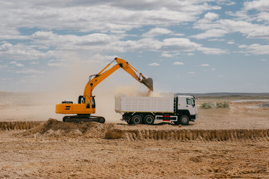 Excavator Loading Soil Into Dump Truck at Construction Site