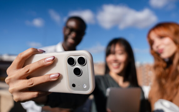 Friends taking selfie with smartphone outdoors