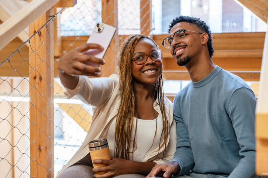 Young couple taking a selfie on wooden stairs