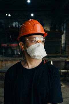 Industrial Worker Wearing Protective Gear in a Factory Environment