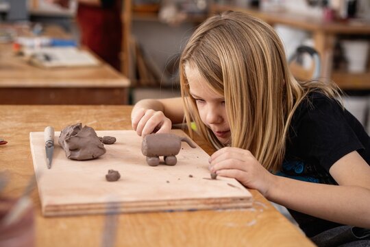 Kid sculpting clay animal figure