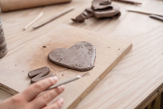 Kid making heart shaped clay sculpture