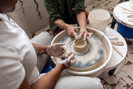 Teacher Helping Student at Pottery Wheel