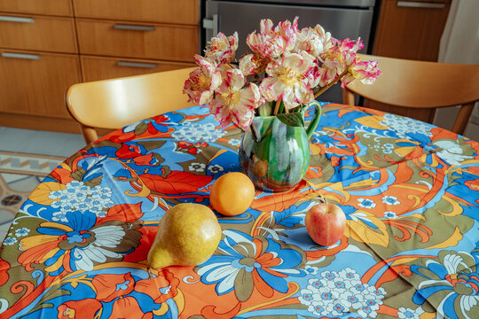 Colorful table setting with flowers and fruit in the kitchen