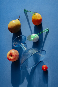 Fruits and glassware arranged on a blue background