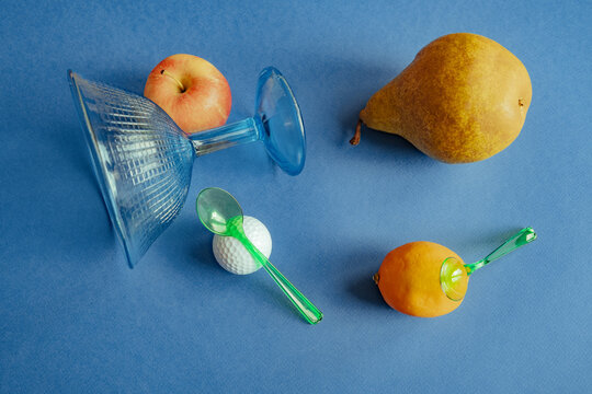 Fruits and objects arranged on a blue surface in still life setup
