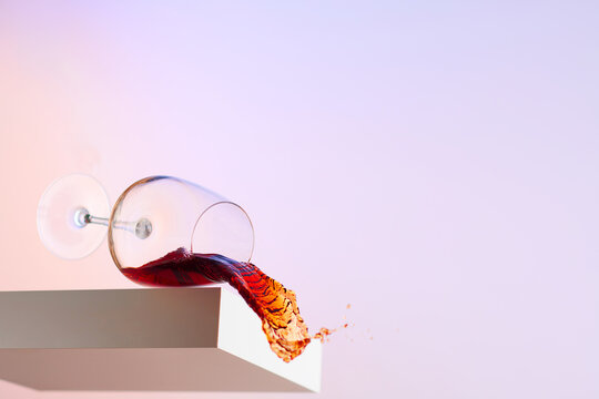 Glass of Red Wine Spilling Out of Glass 