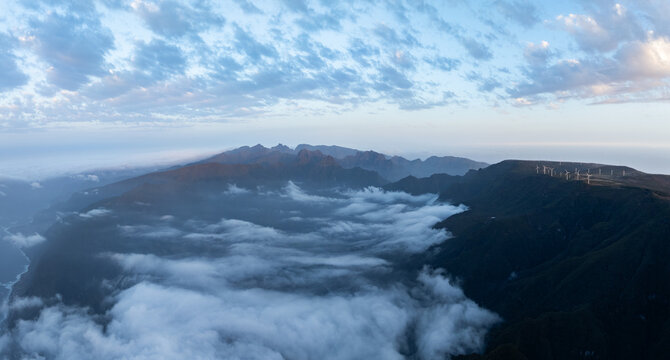 Aerial view of Bica da Cana with mountain peaks rising above a sea of clouds and wind turbines on the plateau in Ponta do Sol, Madeira, Portugal.