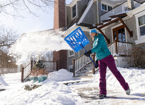 Woman shovels tool snow after snowstorm 