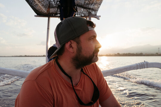 Man Enjoying a Peaceful Sunrise Ride on the Boat in Calm Waters
