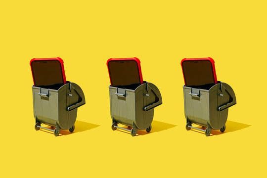 three trash bins holding smartphones on a yellow background