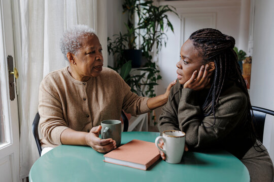 Mother and daughter bonding over empathetic conversation at home
