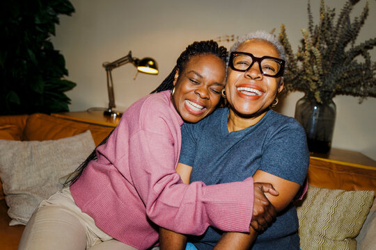 Joyful mother and daughter embracing at home ugc
