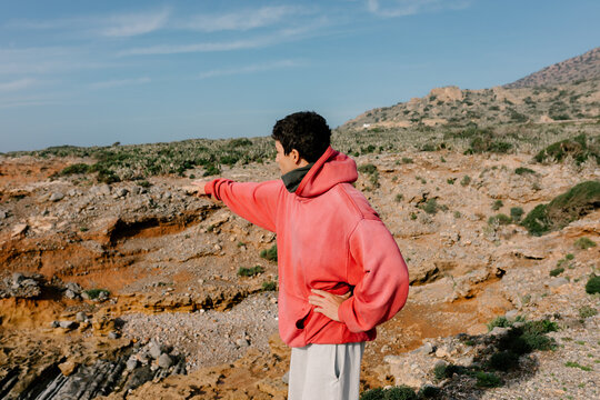 Man surveying the desert landscape of Morocco as he gazes at horizon
